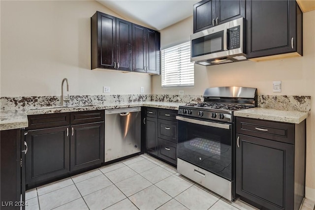 kitchen featuring lofted ceiling, sink, stainless steel appliances, and light tile patterned flooring