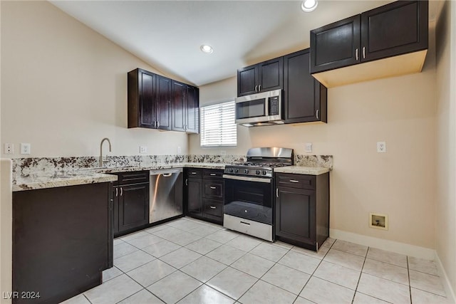 kitchen featuring lofted ceiling, sink, light stone counters, light tile patterned floors, and stainless steel appliances