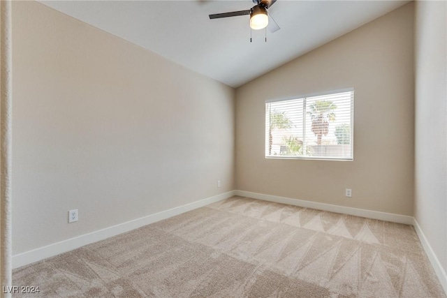 empty room with lofted ceiling, light colored carpet, and ceiling fan