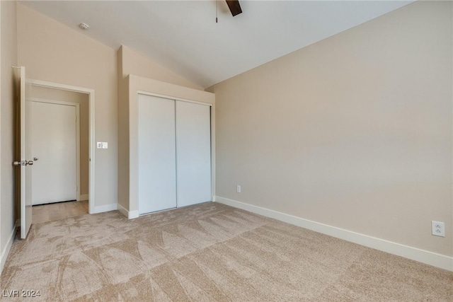 unfurnished bedroom featuring ceiling fan, lofted ceiling, light carpet, and a closet