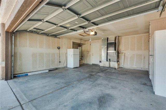 garage with a garage door opener, white fridge, heating unit, and water heater