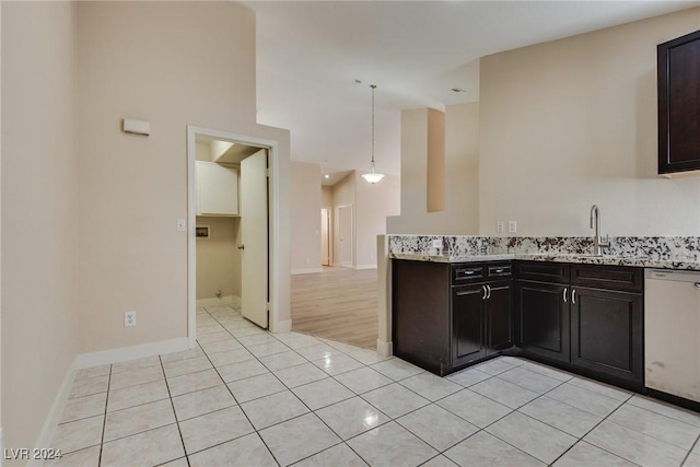 kitchen with dishwasher, light tile patterned floors, dark brown cabinetry, and decorative light fixtures