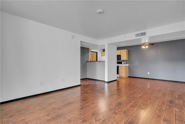 unfurnished living room with hardwood / wood-style flooring and ceiling fan