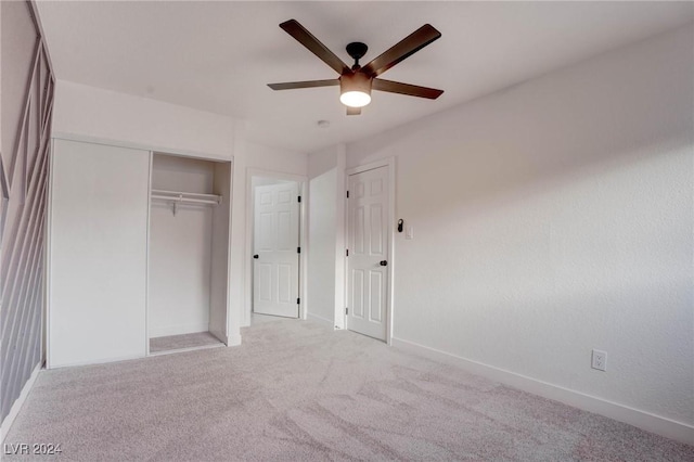 unfurnished bedroom with light carpet, a closet, and ceiling fan