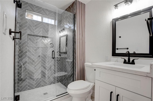 bathroom with vanity, a shower with shower door, and toilet