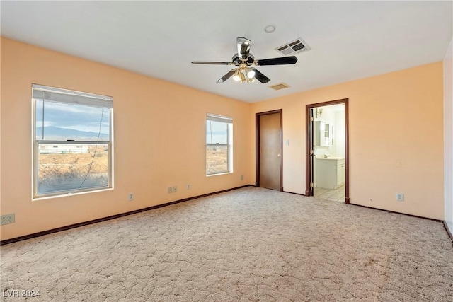 unfurnished bedroom with light carpet, ensuite bath, and ceiling fan