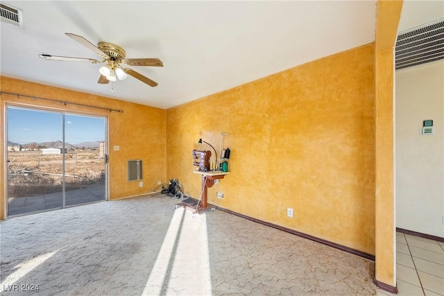 exercise room with ceiling fan and light carpet