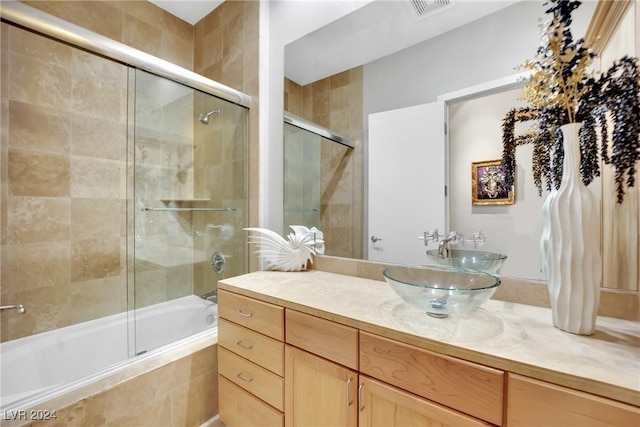 bathroom with vanity and combined bath / shower with glass door