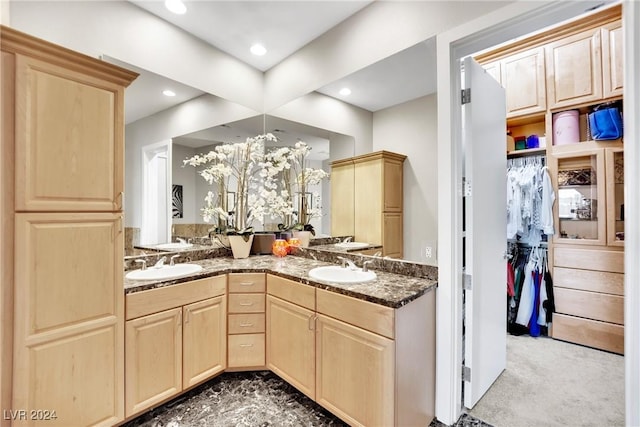 kitchen with carpet flooring, kitchen peninsula, light brown cabinets, and sink