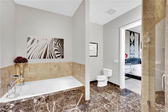 bathroom featuring tiled tub and toilet