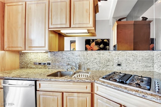 kitchen with light stone countertops, appliances with stainless steel finishes, backsplash, light brown cabinetry, and sink