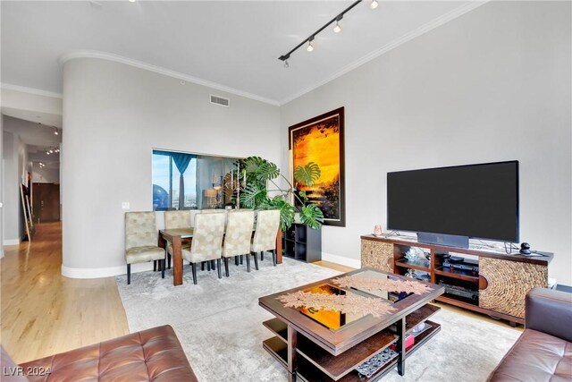 living room featuring hardwood / wood-style flooring, crown molding, and rail lighting