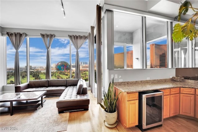 sunroom / solarium with a wealth of natural light, wine cooler, and track lighting