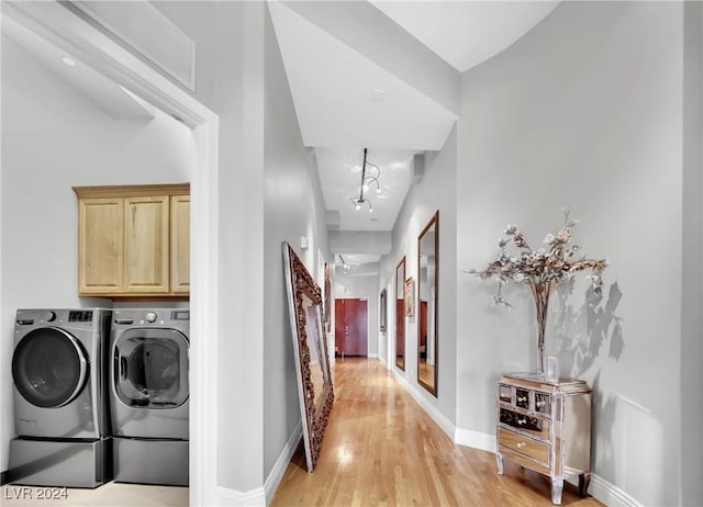 laundry area with cabinets, independent washer and dryer, and light wood-type flooring