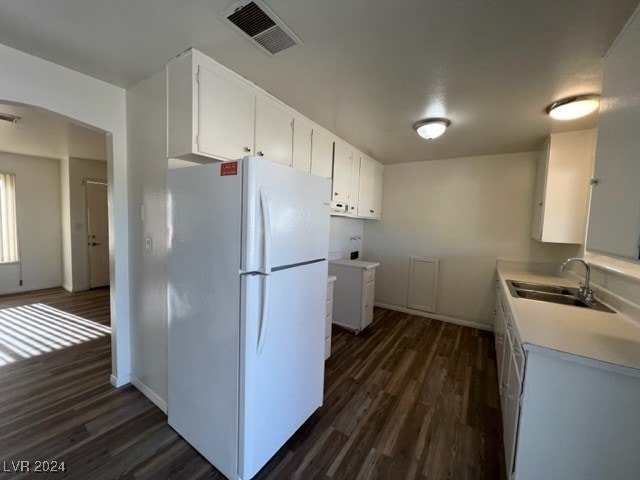 kitchen with white fridge, white cabinetry, dark wood-type flooring, and sink