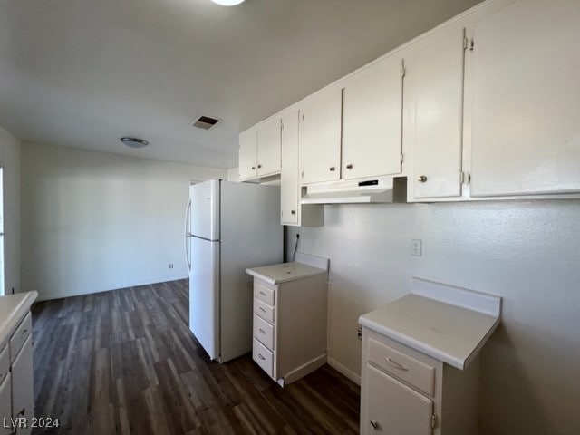 kitchen featuring white cabinetry, dark hardwood / wood-style flooring, and white fridge