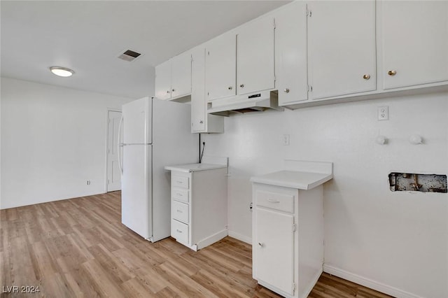 kitchen with white refrigerator, white cabinets, and light hardwood / wood-style floors