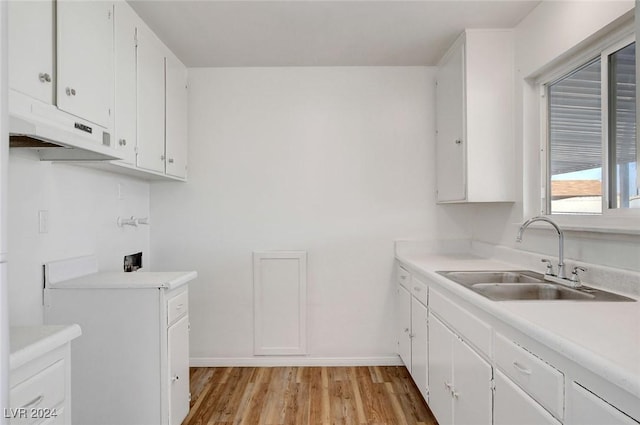 kitchen with light wood-type flooring, sink, and white cabinets