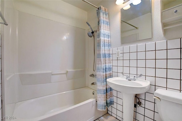 full bathroom featuring shower / bath combination with curtain, toilet, sink, and tile walls