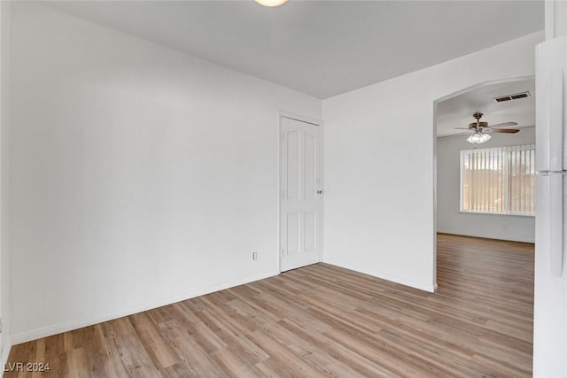 empty room with ceiling fan and light hardwood / wood-style floors