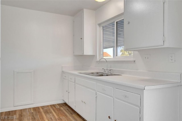 kitchen with white cabinetry, sink, and light wood-type flooring