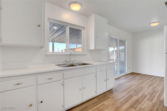 kitchen featuring white cabinetry, sink, and light wood-type flooring