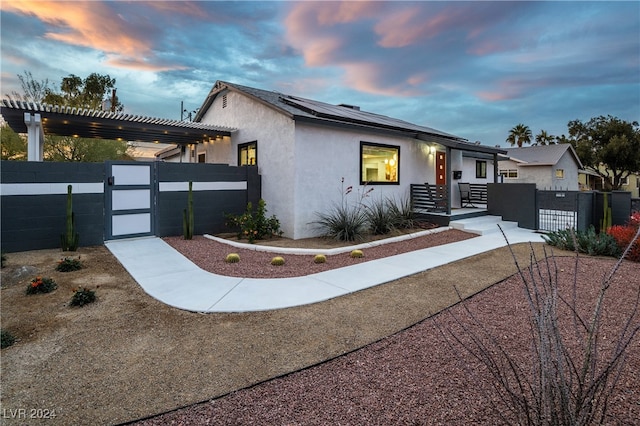 view of front of home featuring solar panels and a pergola