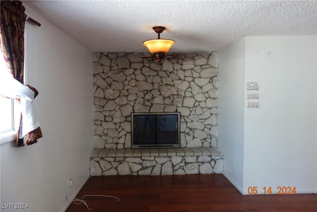 unfurnished living room with a textured ceiling and dark wood-type flooring