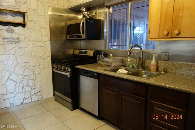 kitchen with tasteful backsplash, sink, light tile patterned floors, and appliances with stainless steel finishes