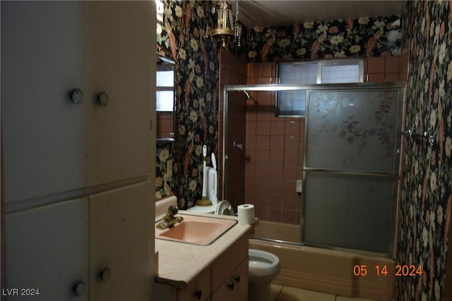 full bathroom with tile patterned flooring, vanity, toilet, and bath / shower combo with glass door