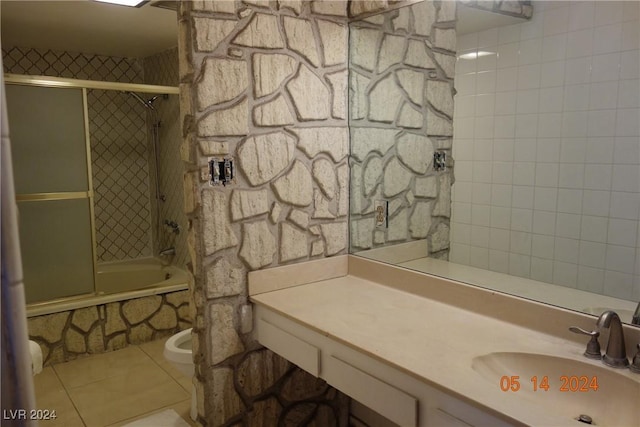 full bathroom with tile patterned flooring, vanity, tiled shower / bath combo, and toilet