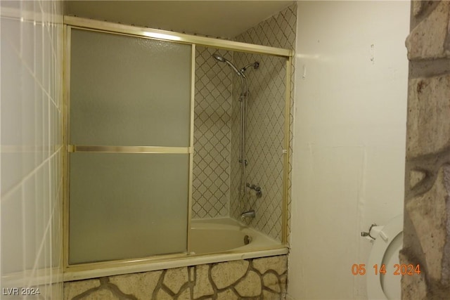 bathroom with combined bath / shower with glass door