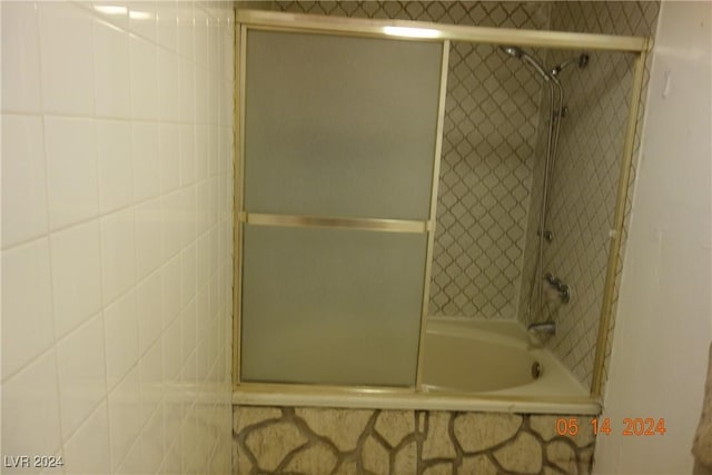 bathroom with shower / bath combination with glass door