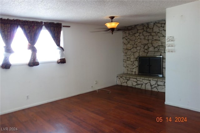 unfurnished living room with a fireplace, dark hardwood / wood-style flooring, and a textured ceiling