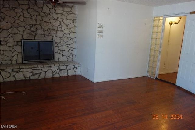 unfurnished living room with a textured ceiling and dark hardwood / wood-style floors