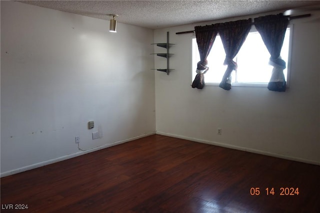 unfurnished room with a textured ceiling and hardwood / wood-style flooring