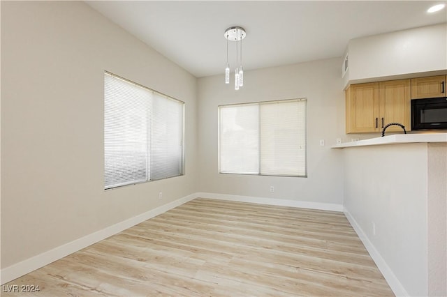 unfurnished dining area with sink and light wood-type flooring