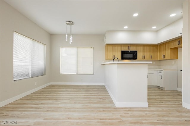 kitchen with light hardwood / wood-style floors, white cabinetry, and hanging light fixtures