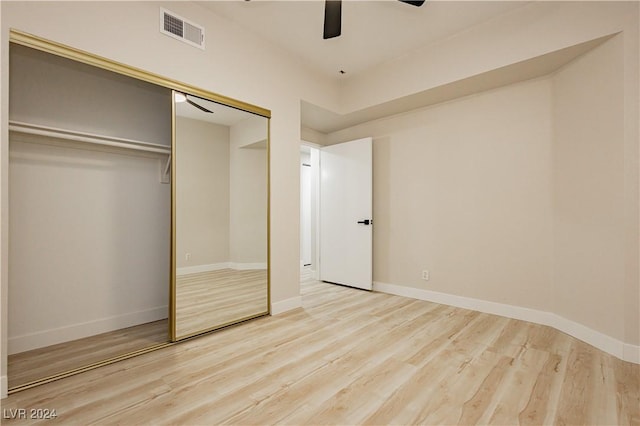 unfurnished bedroom with ceiling fan, a closet, and light wood-type flooring