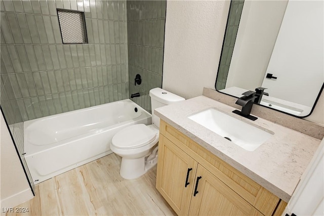 full bathroom with hardwood / wood-style floors, vanity, toilet, and tiled shower / bath