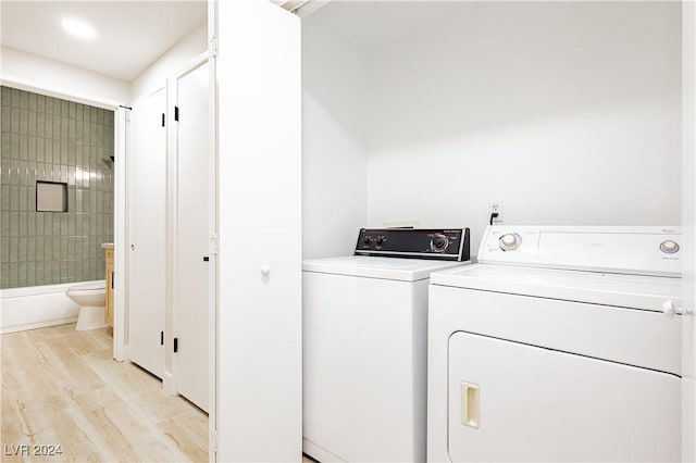 washroom featuring washing machine and dryer and light wood-type flooring