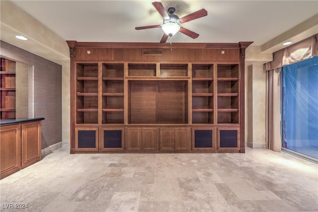 unfurnished living room with built in features and ceiling fan