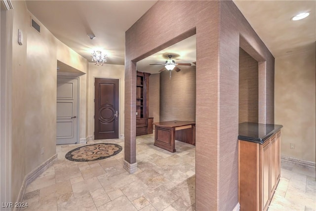 entrance foyer with ceiling fan with notable chandelier