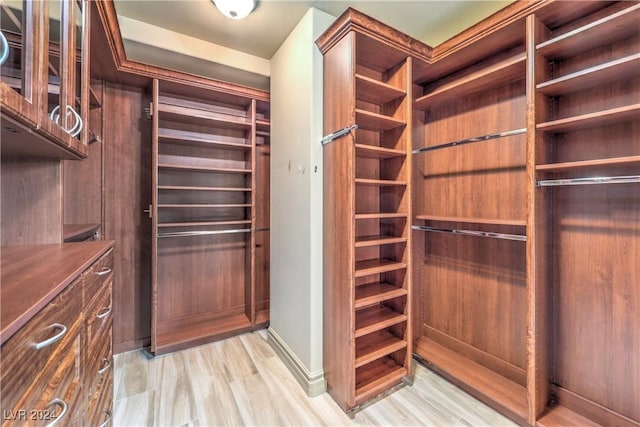 walk in closet with light wood-type flooring