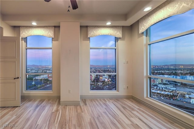 spare room with light wood-type flooring and ceiling fan