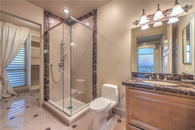 bathroom featuring toilet, tile patterned flooring, a shower with shower door, and vanity