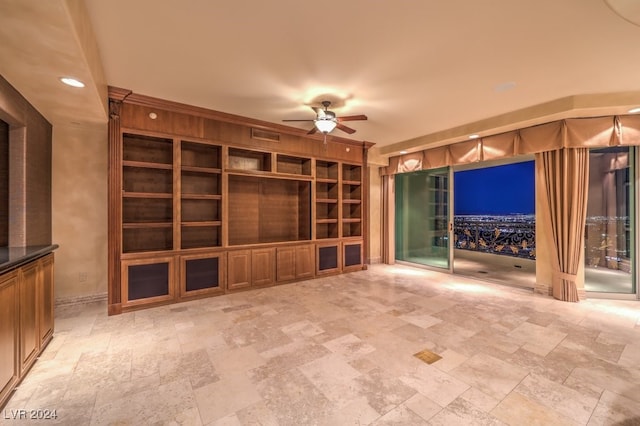 empty room with built in shelves and ceiling fan