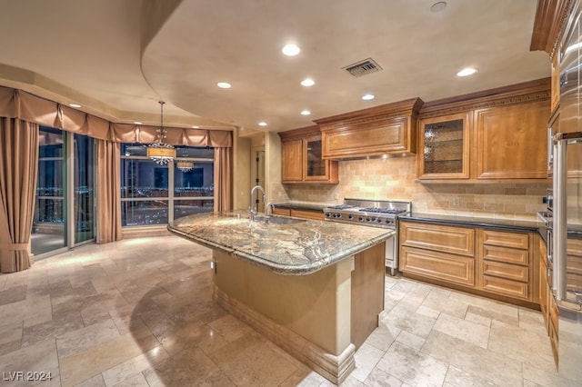 kitchen with stainless steel stove, custom range hood, a kitchen bar, an island with sink, and hanging light fixtures