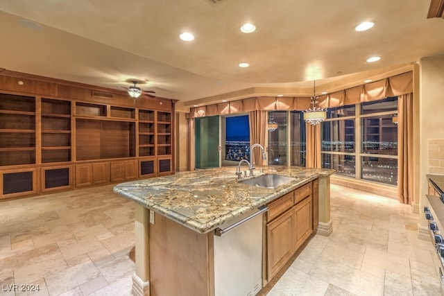 kitchen with a large island, ceiling fan, pendant lighting, sink, and built in features