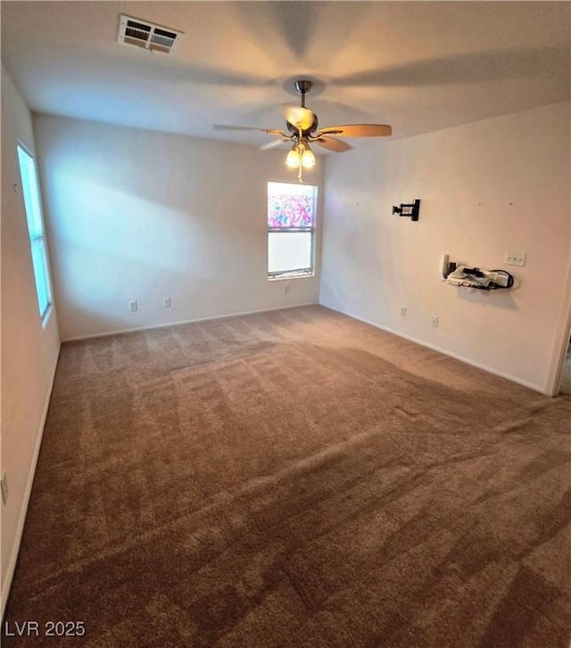 carpeted spare room featuring ceiling fan